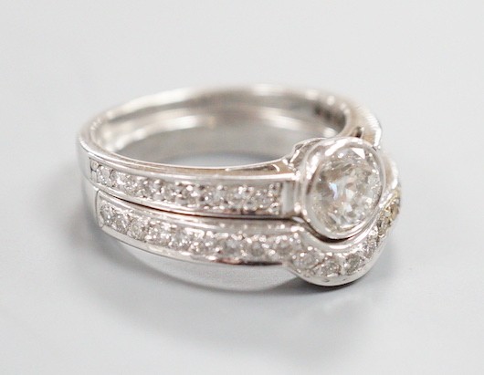 A modern 18ct white gold and collet set single stone diamond ring, with diamond set shoulders and 18ct and diamond set fitted wedding band, size J/K, gross weight 7.8 grams
